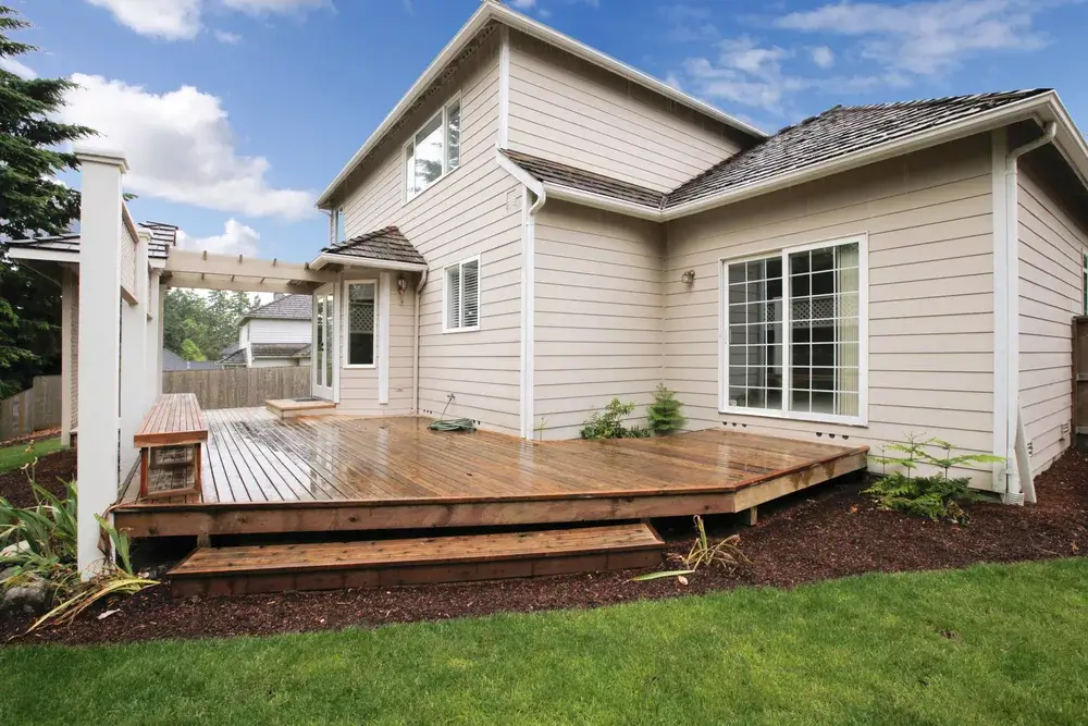 photo of a custom deck with built-in benches and pergola cover